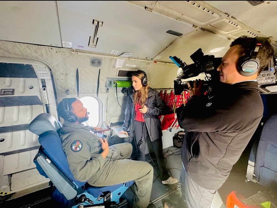 Reporter interviewing pilot inside aircraft